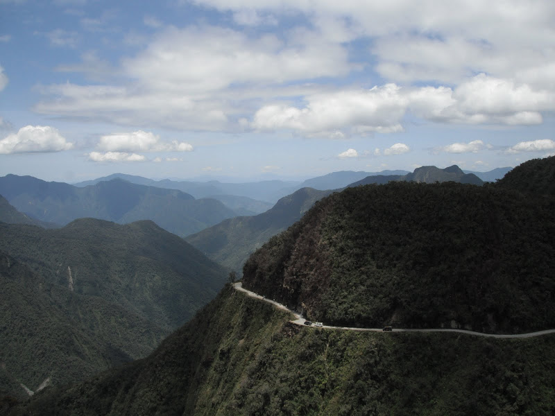 Cycling death road in Bolivia has views like this one of snaking roads around lush hillsides.